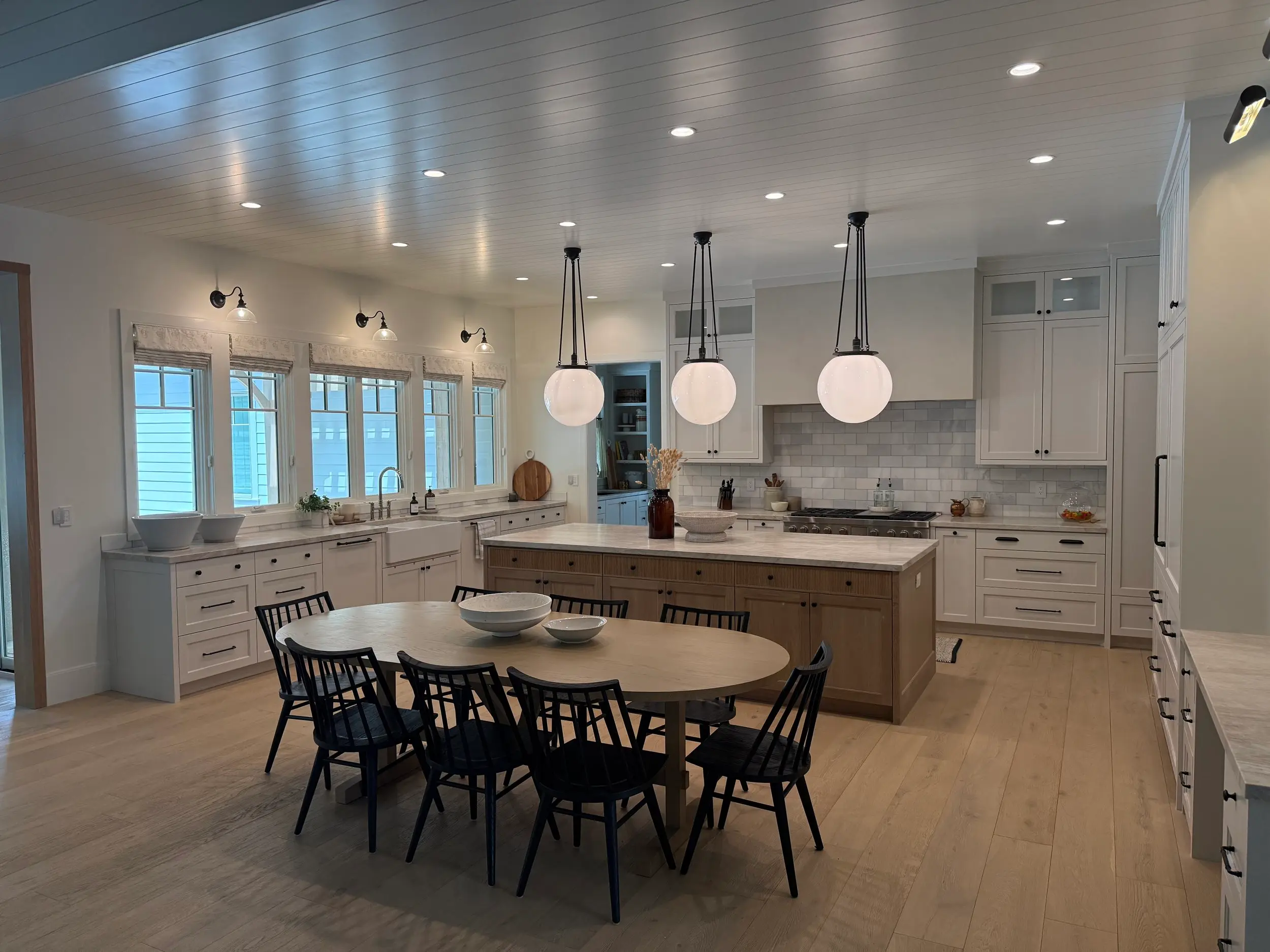 Custom white shaker cabinetry with a large center island, showcasing precision joinery and a hand-finished quartz countertop by the cabinet maker.