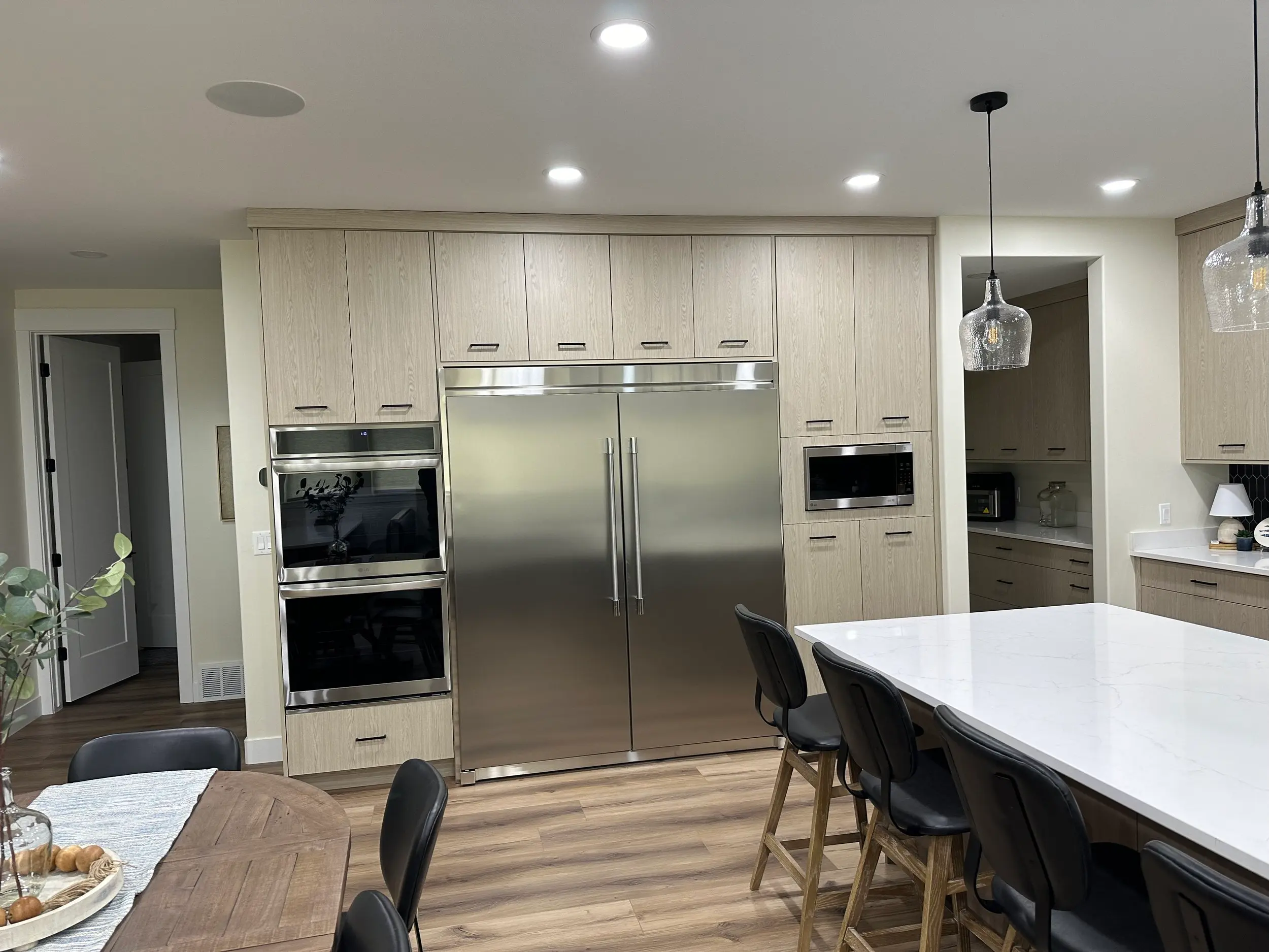 Custom-fabricated panel-ready refrigerator cabinet, built and fitted flush with surrounding cabinetry to seamlessly conceal the appliance — a signature integration technique.