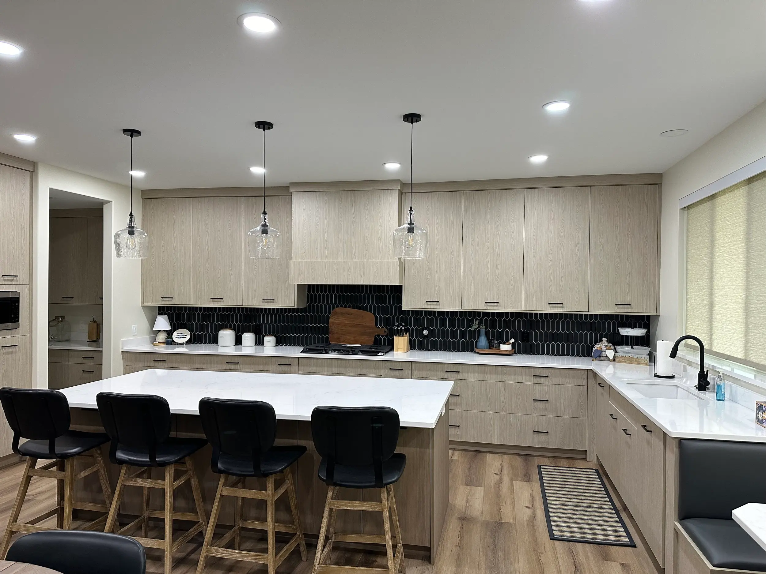 The ECO Line natural wood cabinetry finished with hand-selected black hardware, demonstrating the shop's paint and hardware pairing craftsmanship.