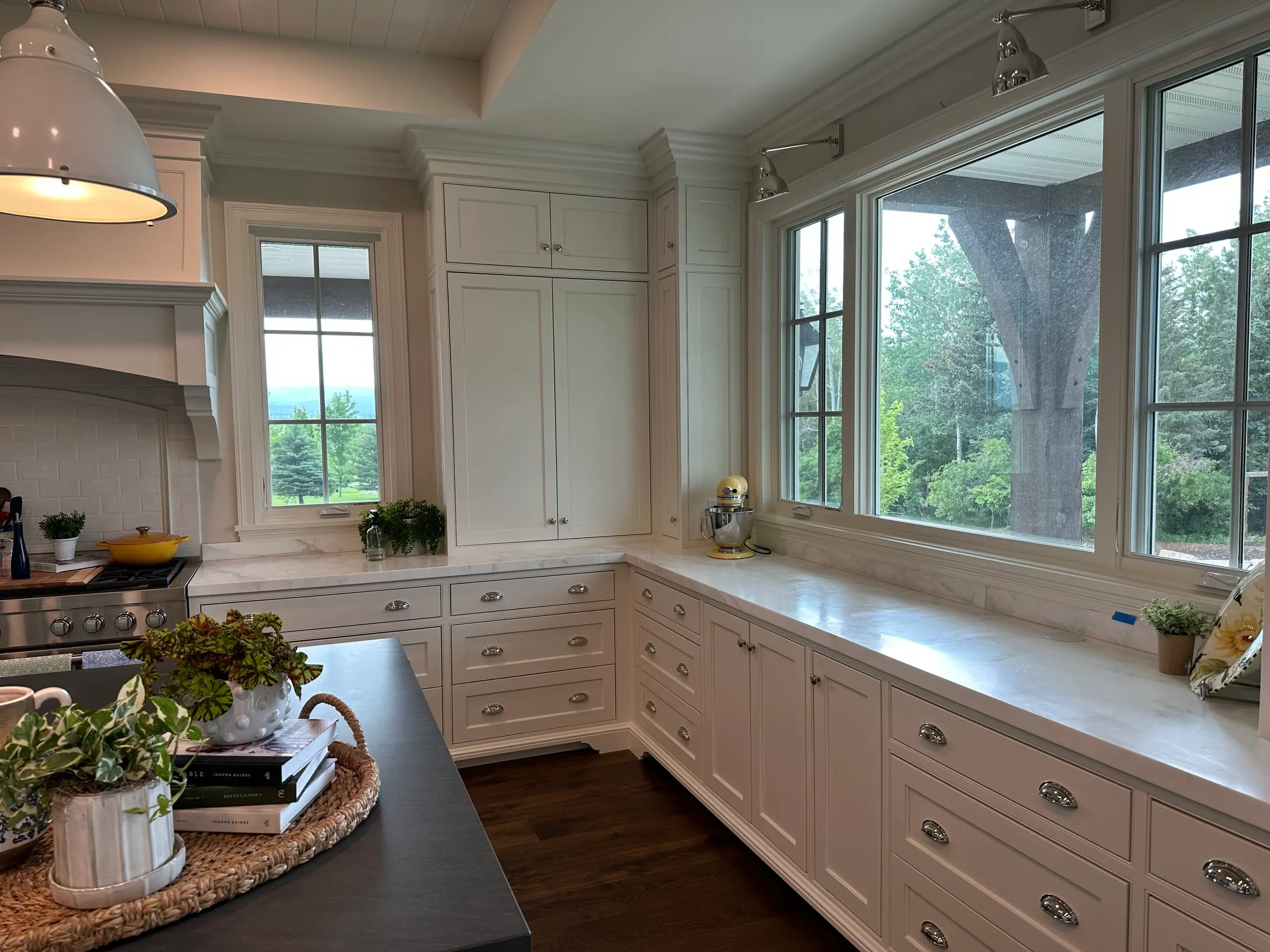 Custom white cabinetry countertop run along a bank of windows, showcasing finished panel detailing and craftsmanship.