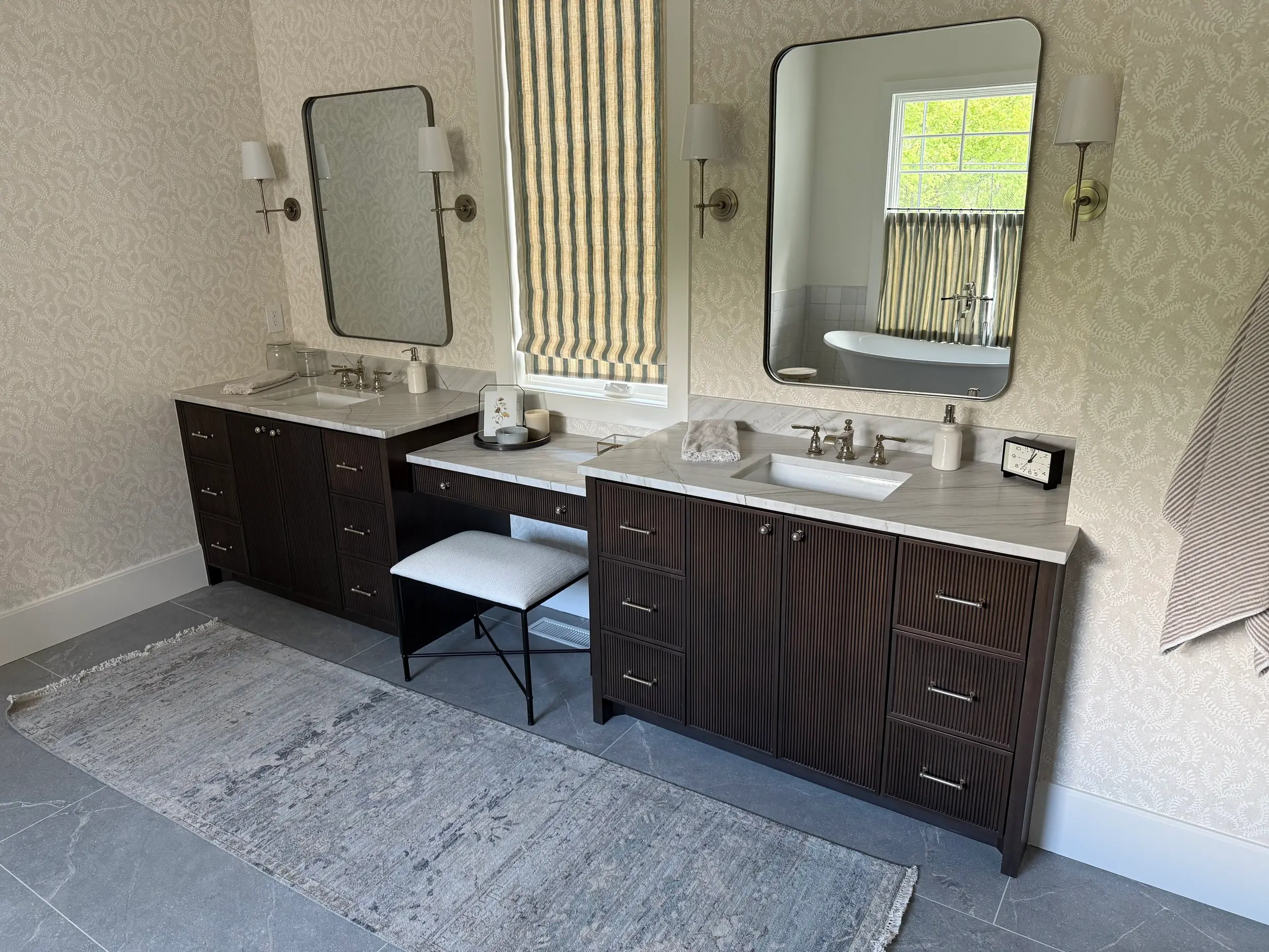 Luxury primary bathroom featuring marble countertops, dual sinks, backlit mirrors, and a spacious glass-enclosed shower with rainfall shower head fixture.